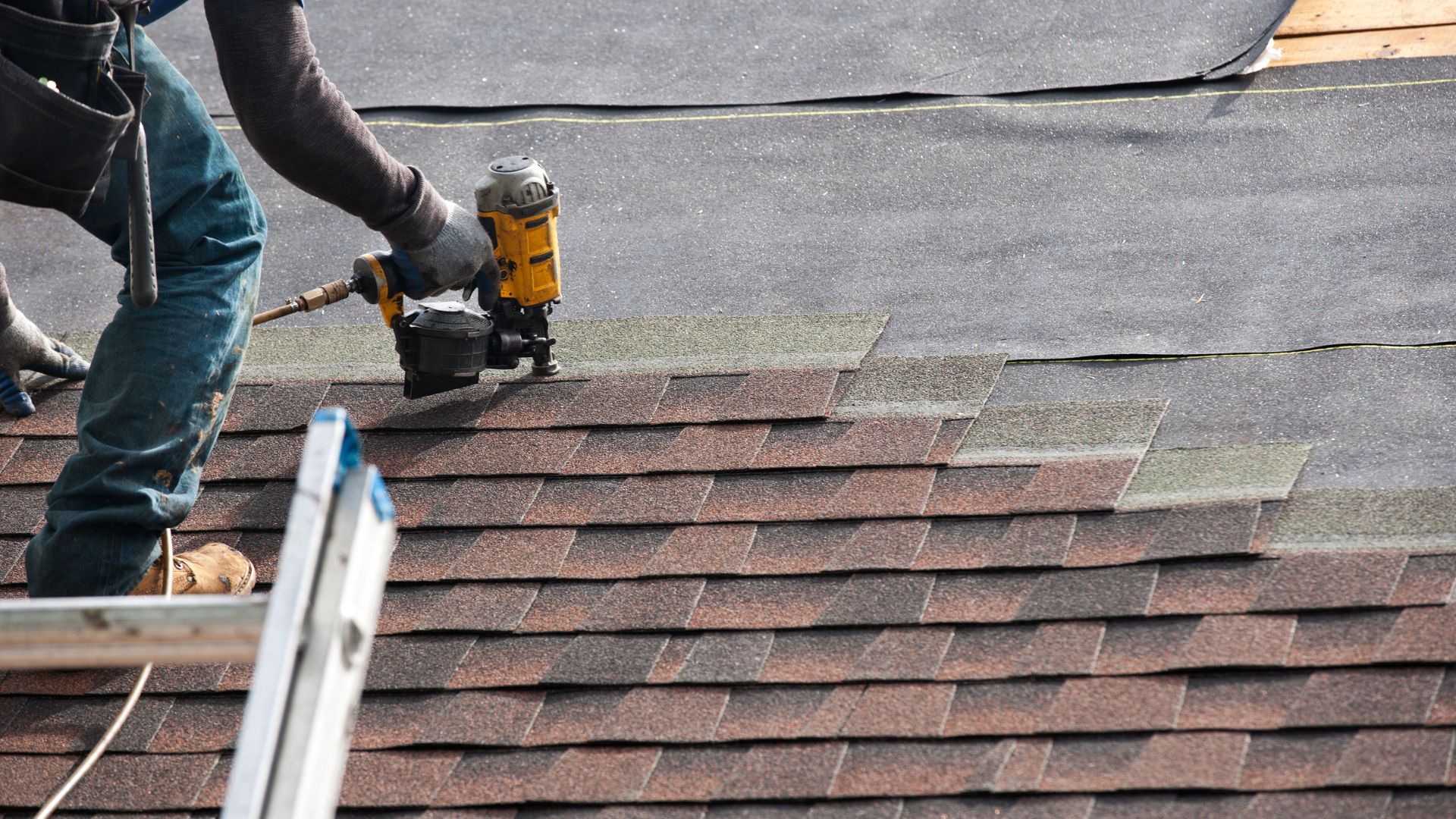 roofer nailing a shingle